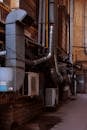 Close-up of urban building exterior with air conditioning units and pipes in an industrial district.